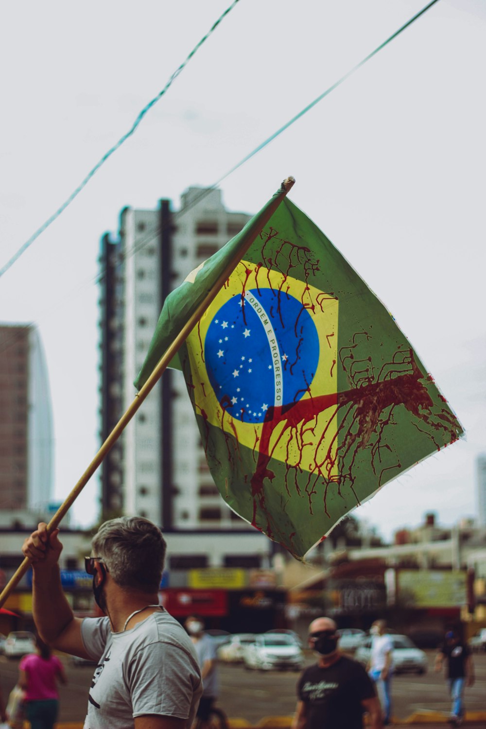 man in green shirt holding yellow and green flag