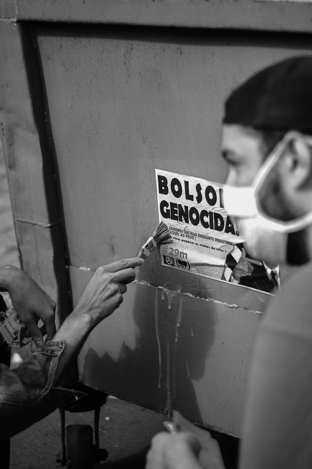 Un hombre con una máscara al poner un periódico en una caja