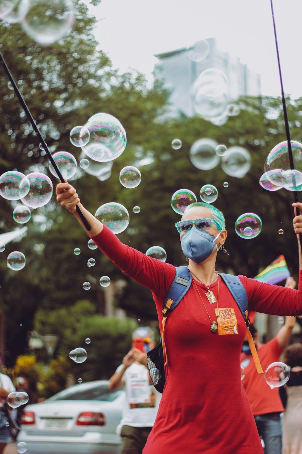 woman in red long sleeve shirt with blue goggles and red gloves holding bubbles