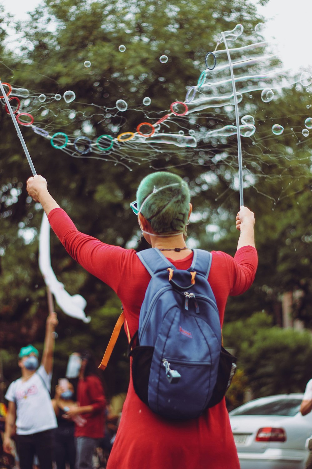 man in red and blue jacket playing bubbles