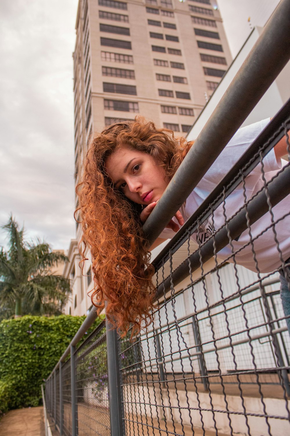 woman in black shirt standing near brown metal fence during daytime