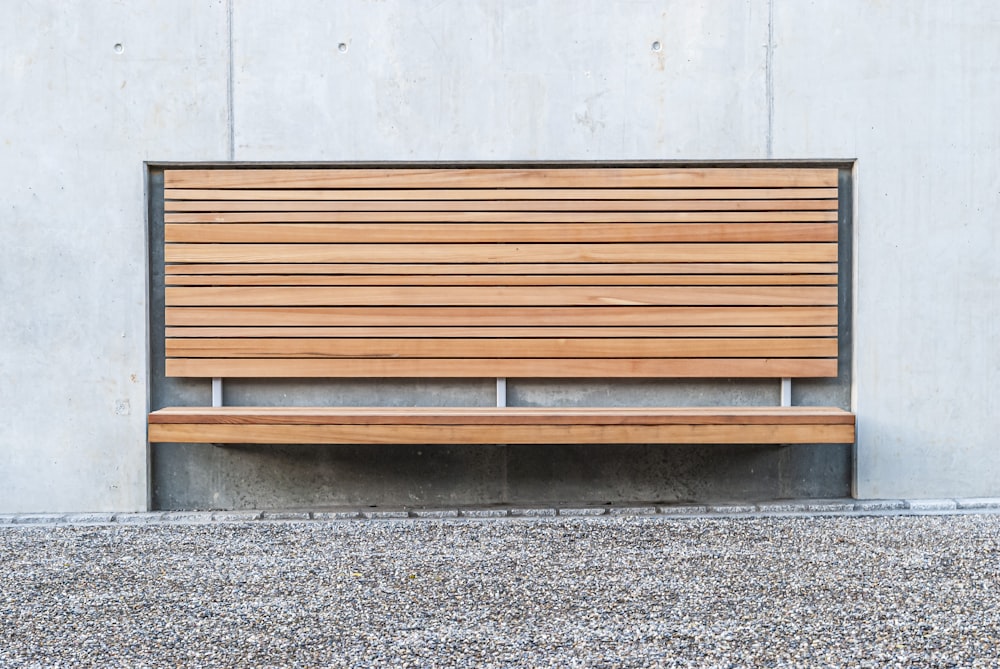 brown wooden bench near white wall