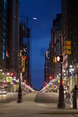 Street lights illuminating a city street at dusk.