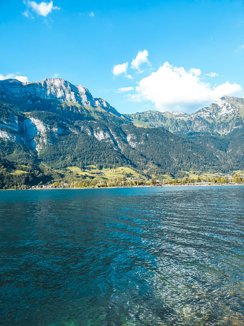 body of water near mountain during daytime