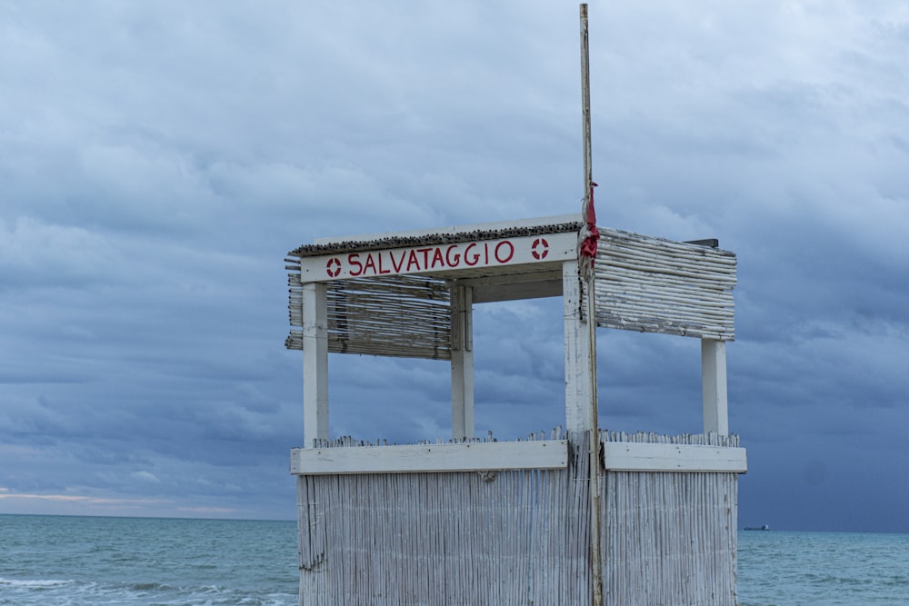white and red wooden signage on sea dock during daytime