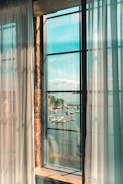 A welcoming office space with nautical decor and a large window overlooking a marina filled with yachts.