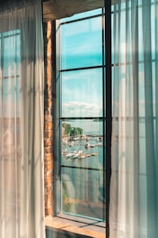 A bright, airy living room overlooking the marina with boats docked outside.