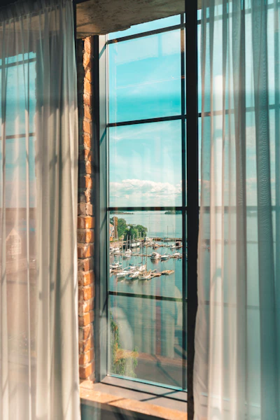 A welcoming office space with nautical decor and a large window overlooking a marina filled with yachts.