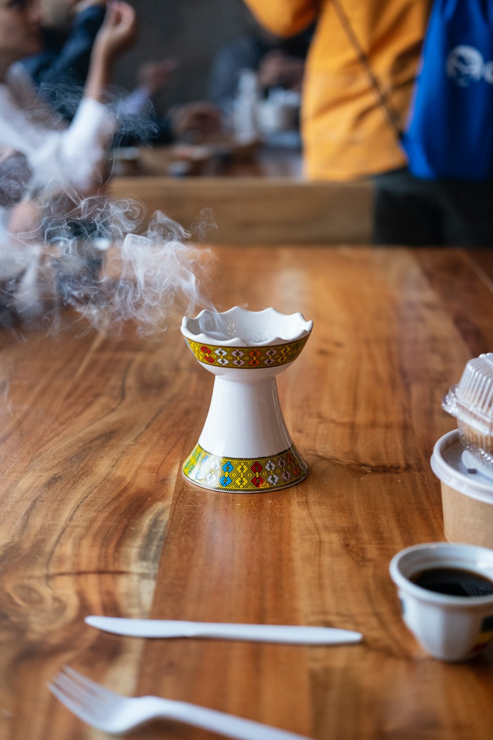 white and gold ceramic cup on brown wooden table