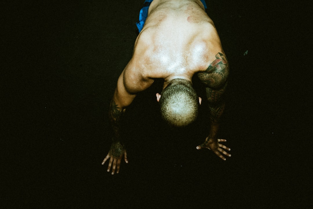 man in blue shorts lying on black surface