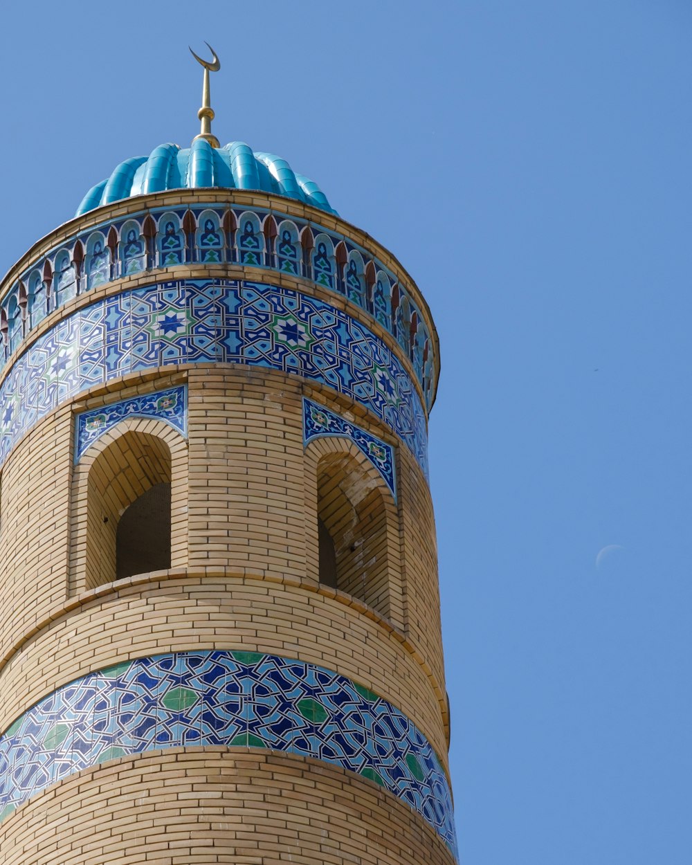 Edificio in cemento verde e marrone sotto il cielo blu durante il giorno