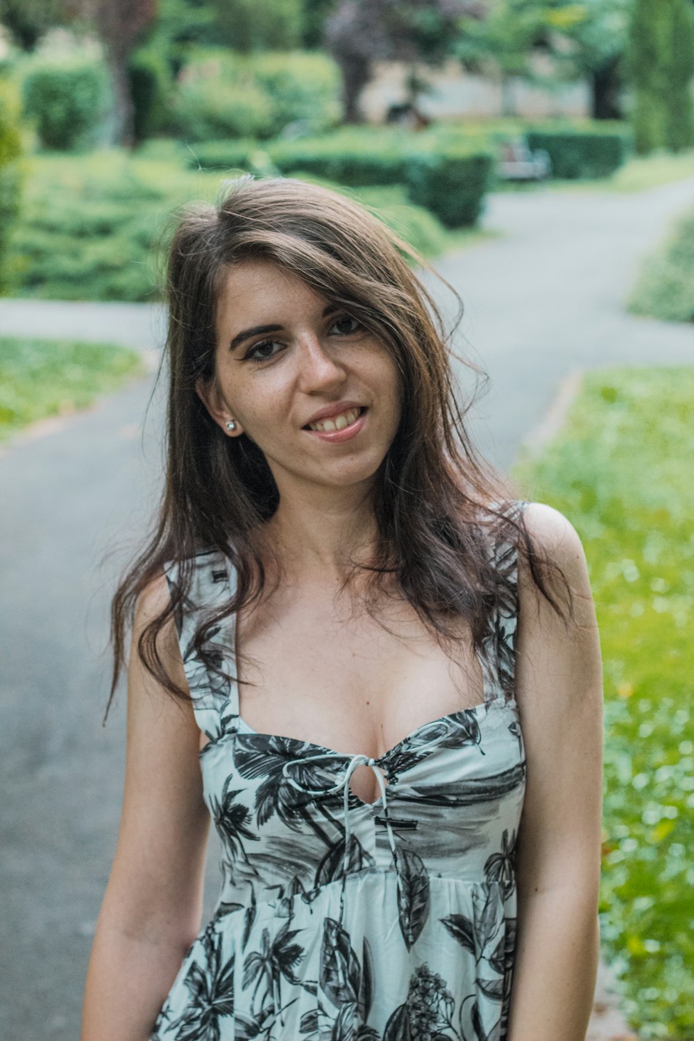 woman in blue and white floral spaghetti strap top smiling