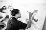 An artist painting a canvas inspired by themes of resilience and identity.
