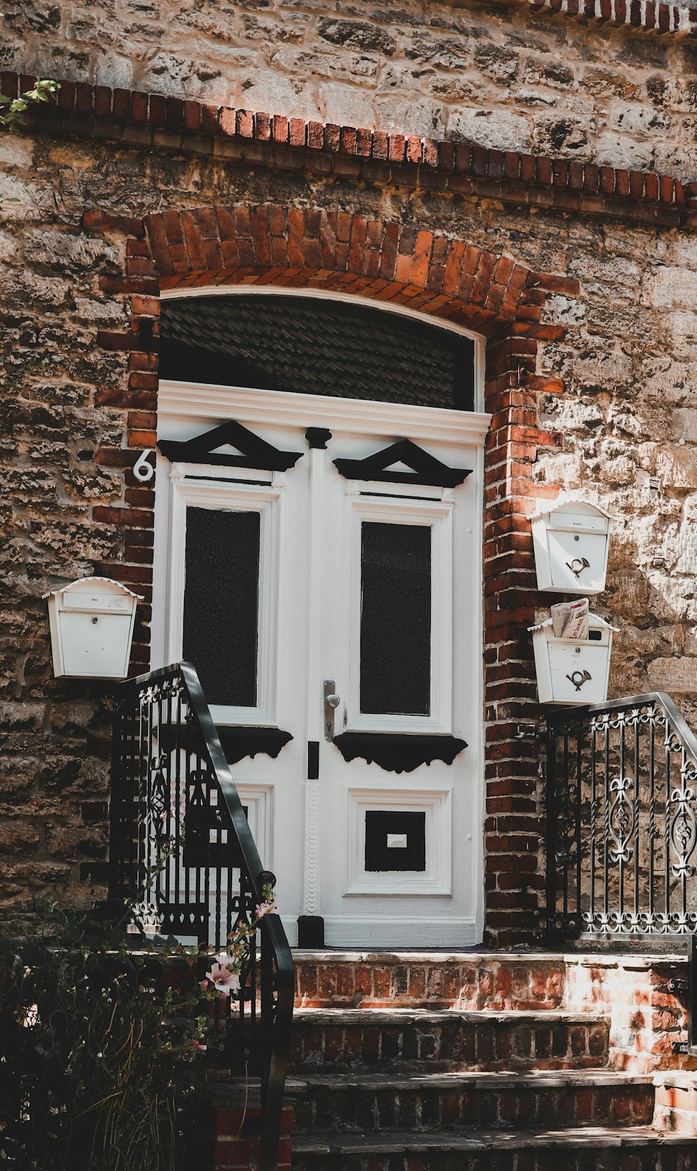 white wooden door on brown brick wall