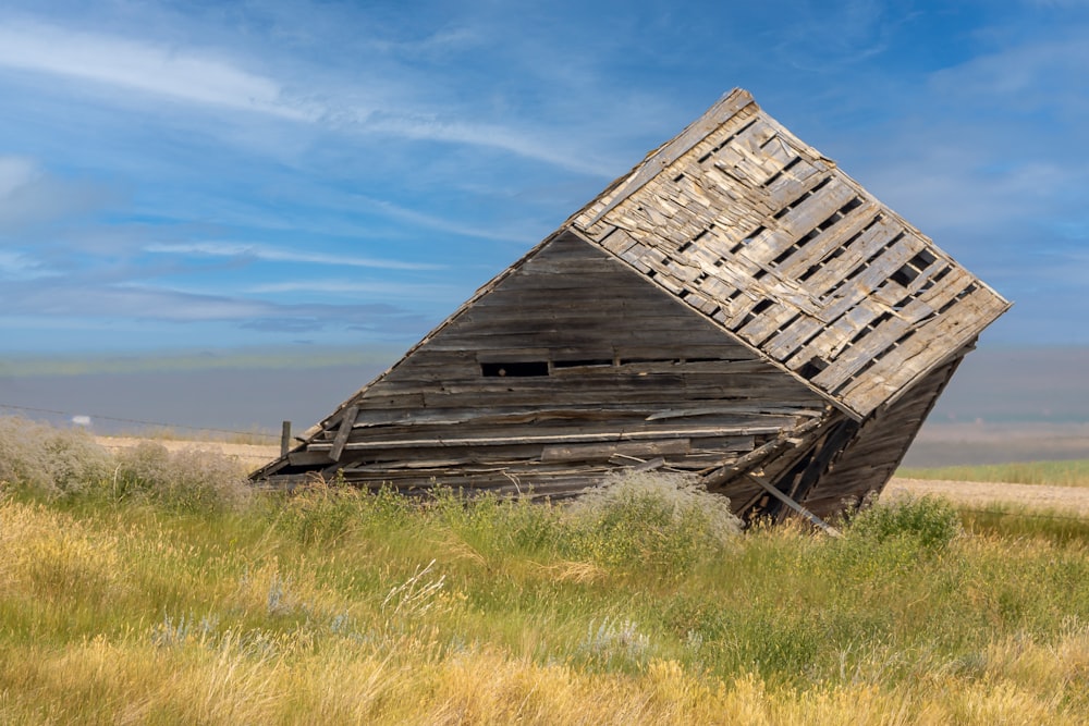 brown wooden barn on green grass field under blue sky during daytime