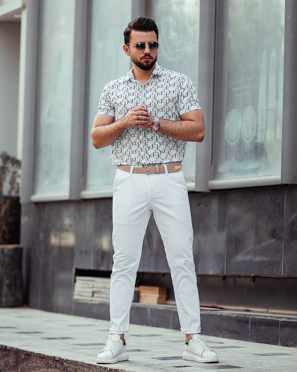 man in white pants and blue and white checkered button up shirt standing on gray concrete