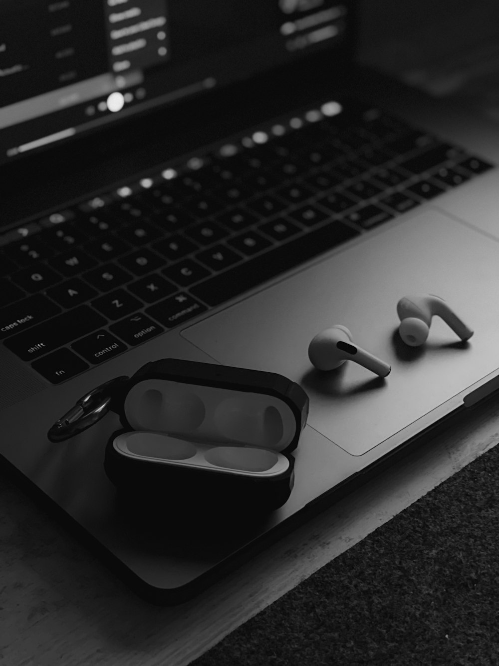 white and black earbuds on macbook pro