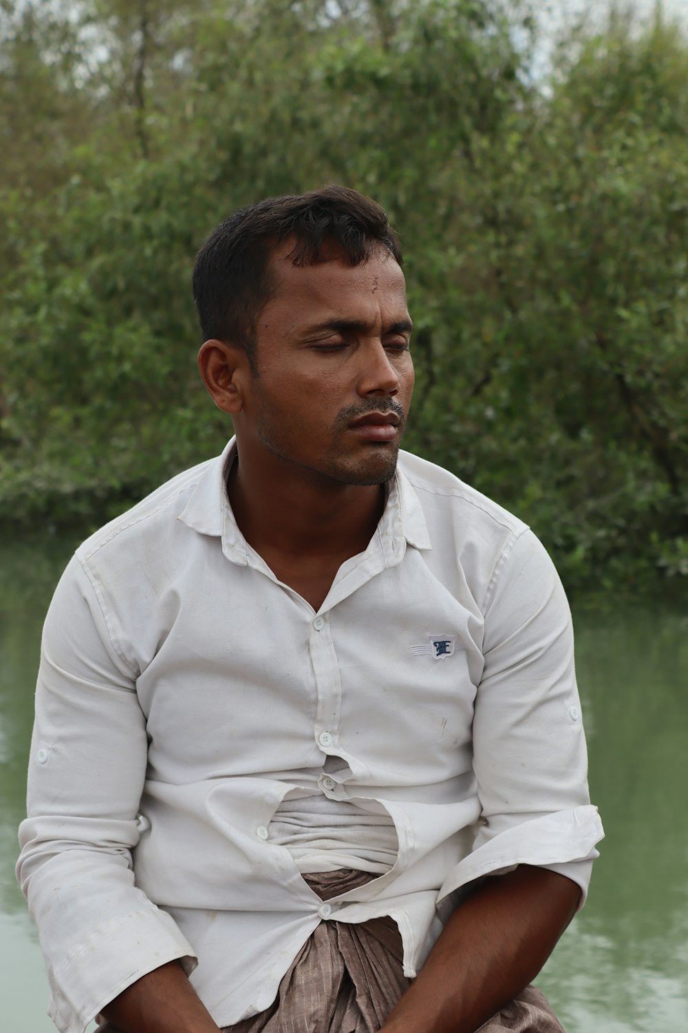 man in white dress shirt standing on green grass field during daytime