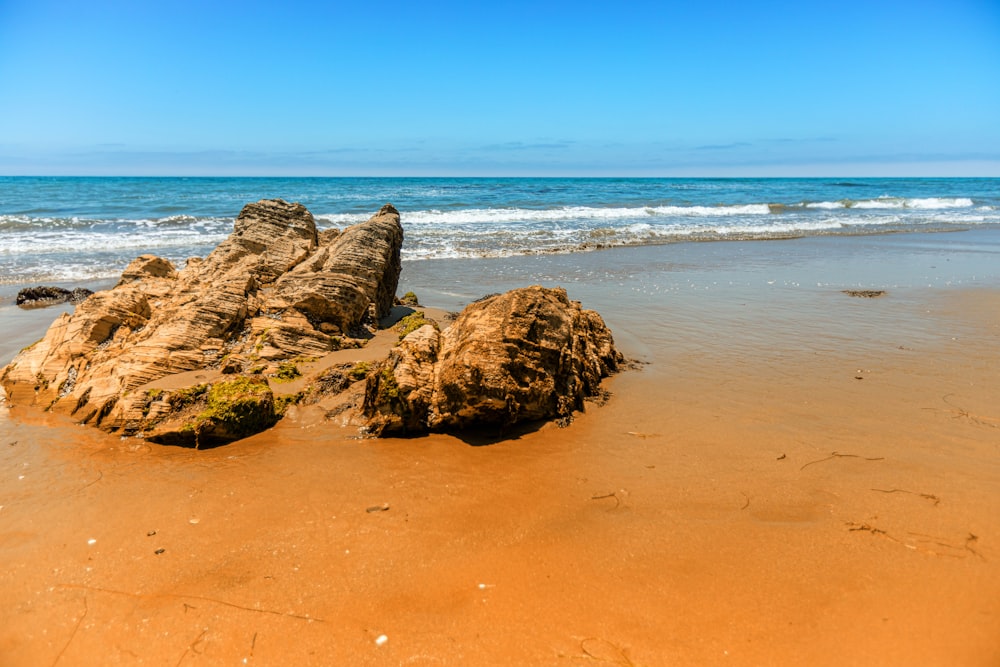 brown rock formation on seashore during daytime