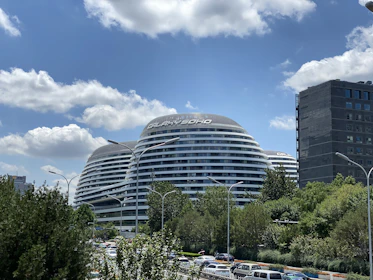 An elegant 3D animation snapshot of a futuristic building surrounded by landscaped greenery.