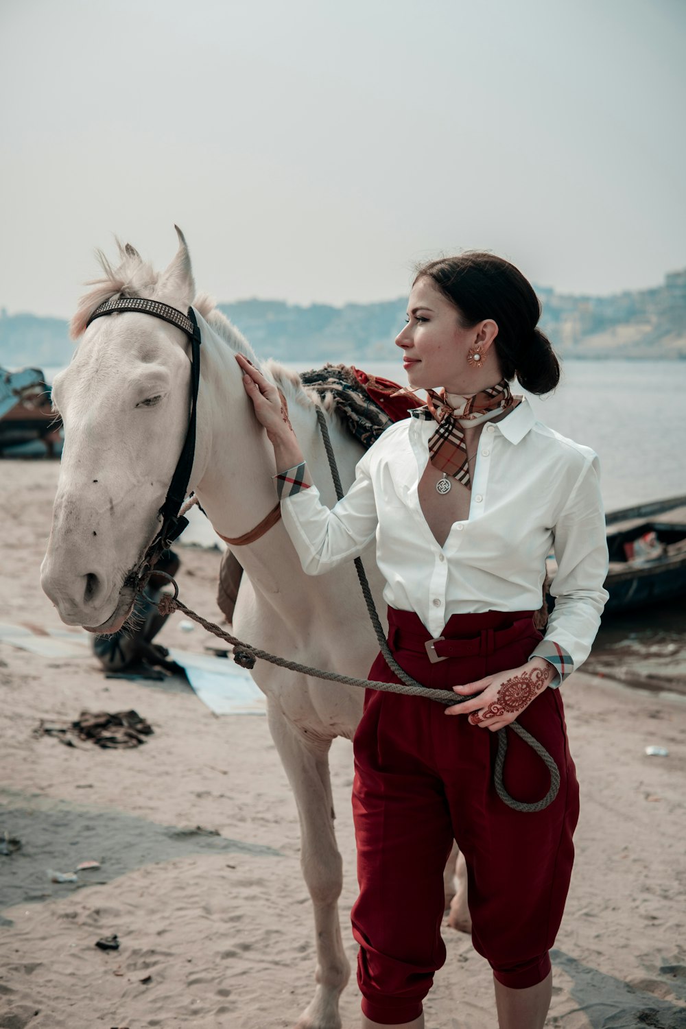 woman in white long sleeve shirt riding white horse during daytime
