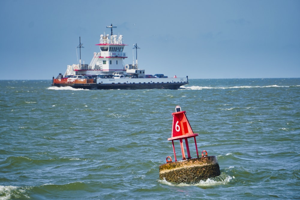 red and white lighthouse on brown rock formation in the middle of sea during daytime