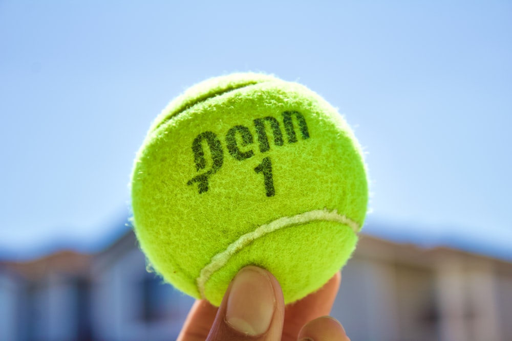 green tennis ball on hand