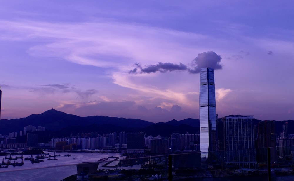 white concrete building near mountain under cloudy sky during daytime