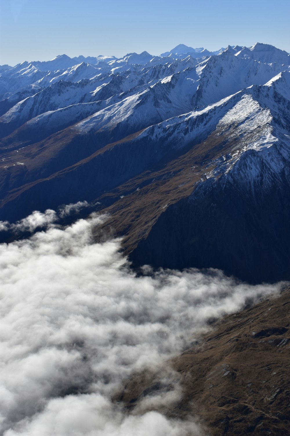 brown and white mountains under white clouds during daytime