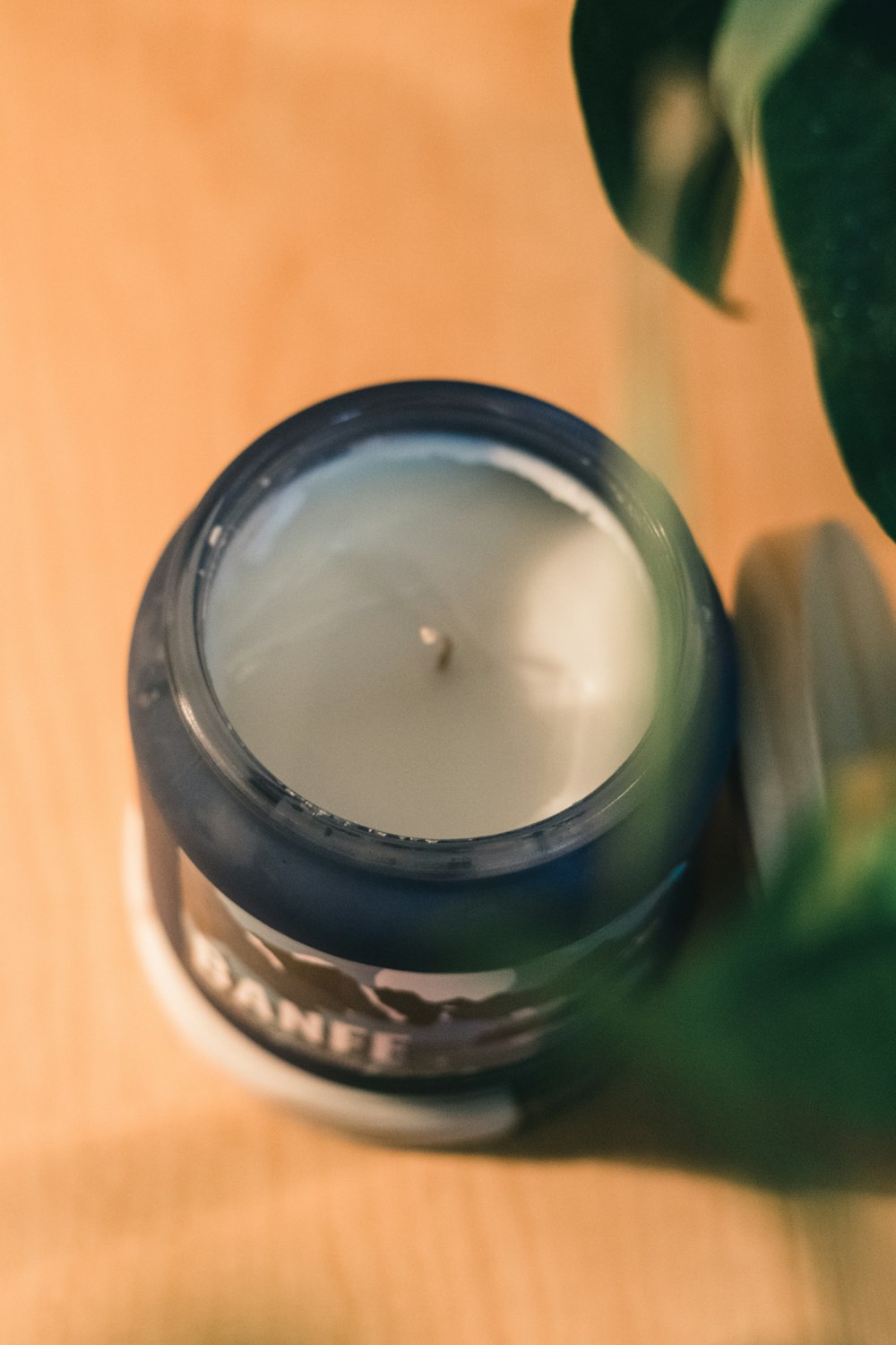 white candle in glass jar
