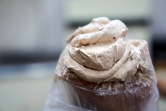 A close-up of a rich chocolate cupcake topped with swirls of creamy frosting and colorful sprinkles.