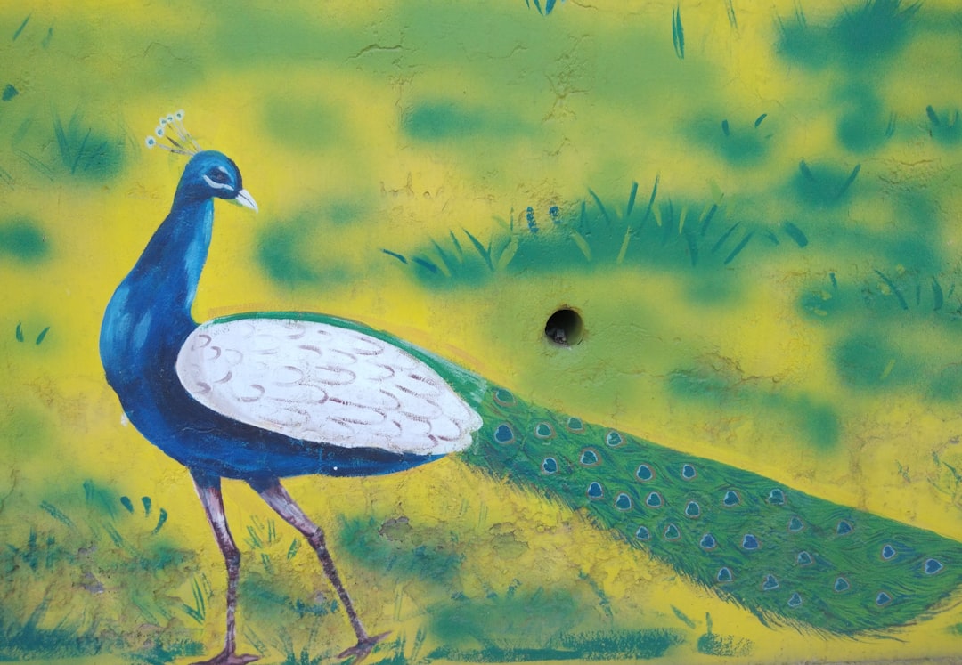 blue peacock standing on green grass field painting