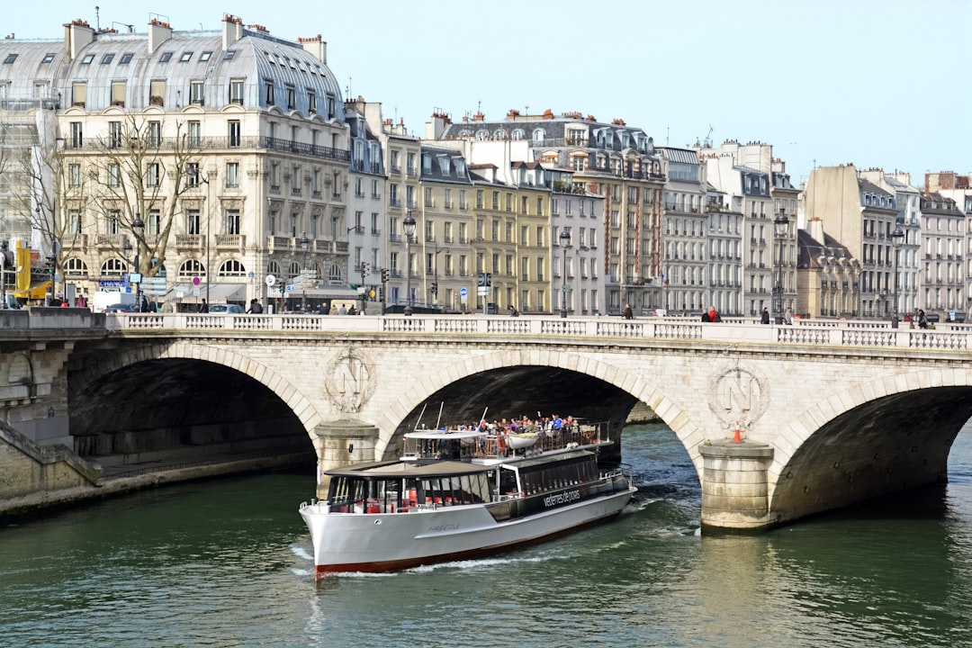 white and red boat on river near bridge during daytime