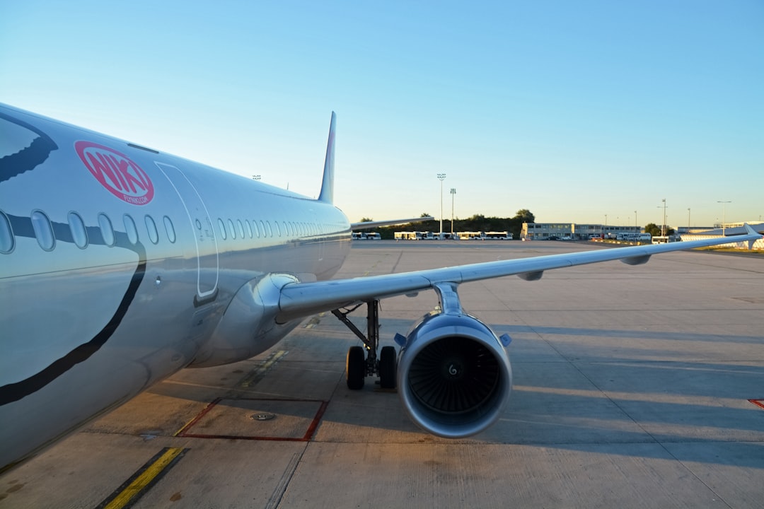 white and blue airplane on airport during daytime