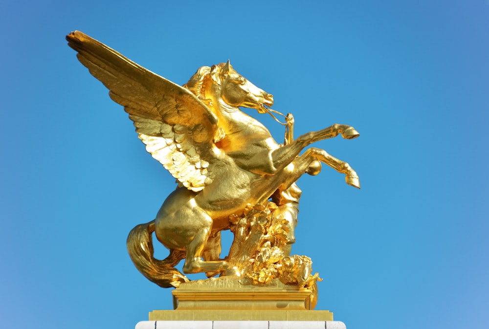 gold angel statue under blue sky during daytime