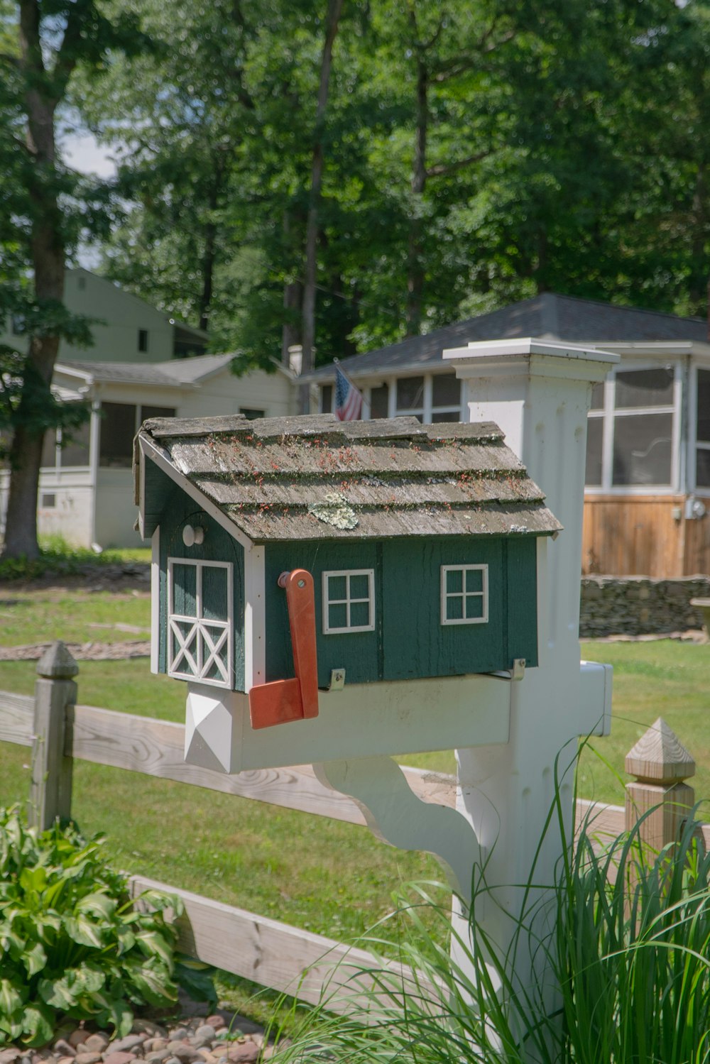 white and red wooden house on green grass field during daytime