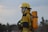 man in yellow hard hat and yellow jacket carrying black dslr camera