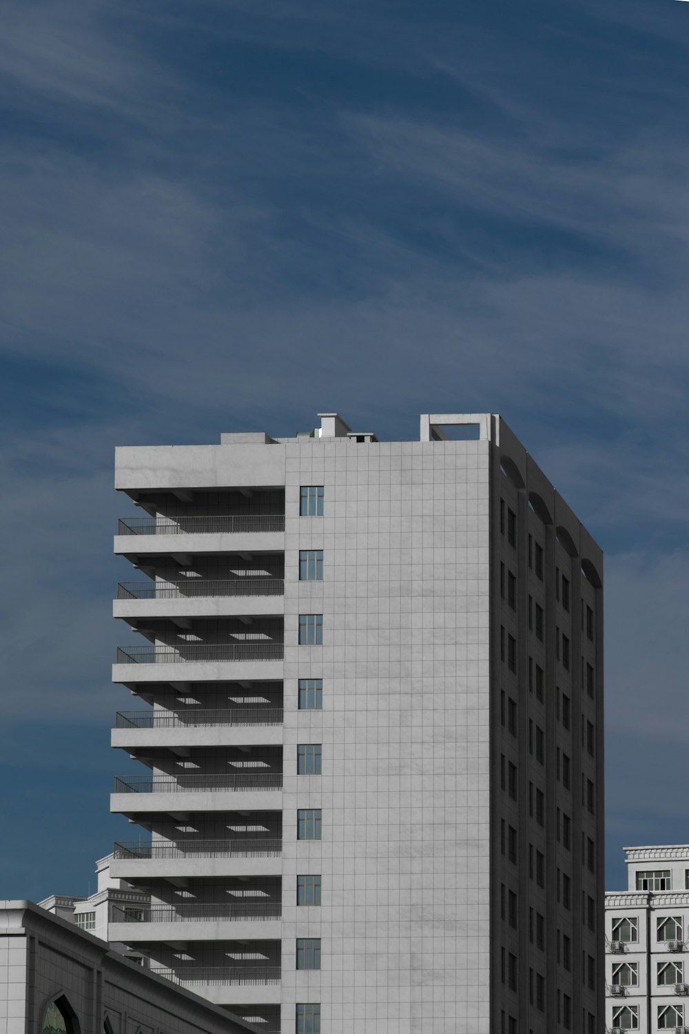 Edificio in cemento bianco e nero sotto il cielo blu durante il giorno