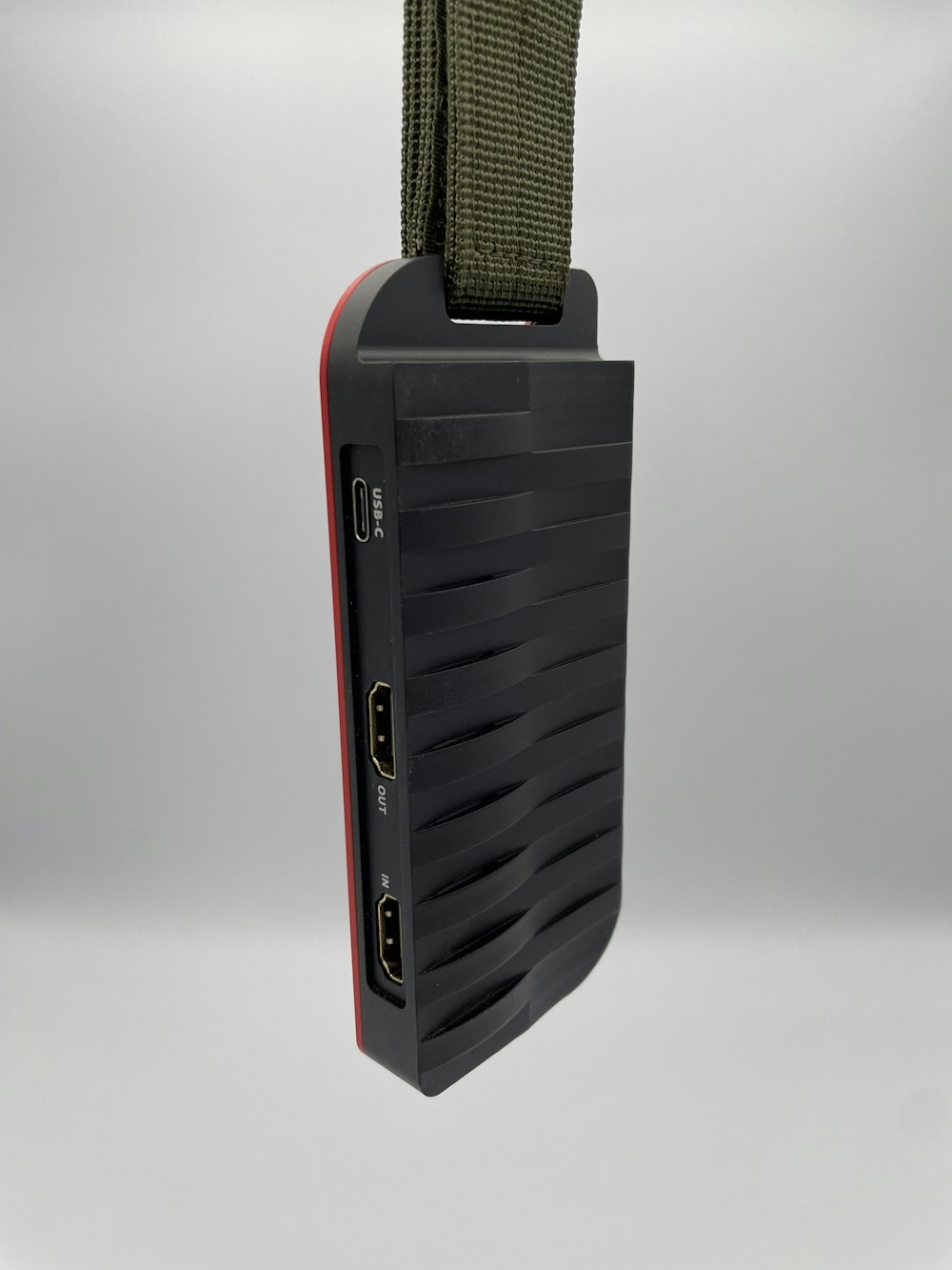 a black and red device hanging from a cord