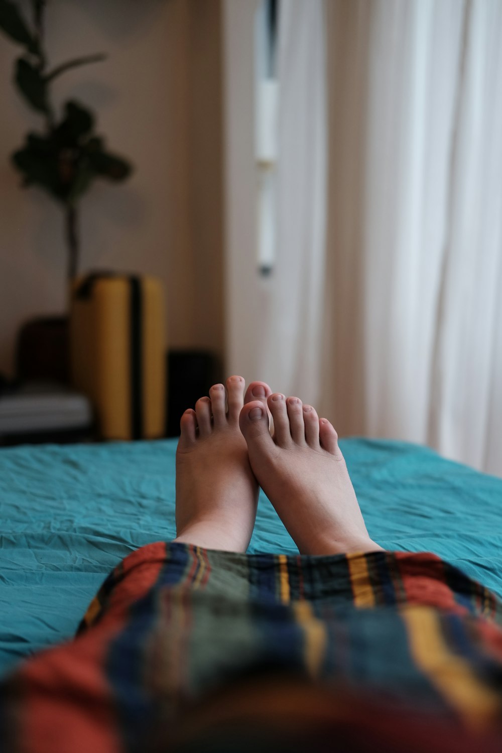 ベッドに横たわる青と赤の格子縞のスカートの人