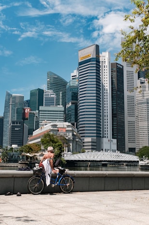 man in white shirt riding bicycle on road during daytime