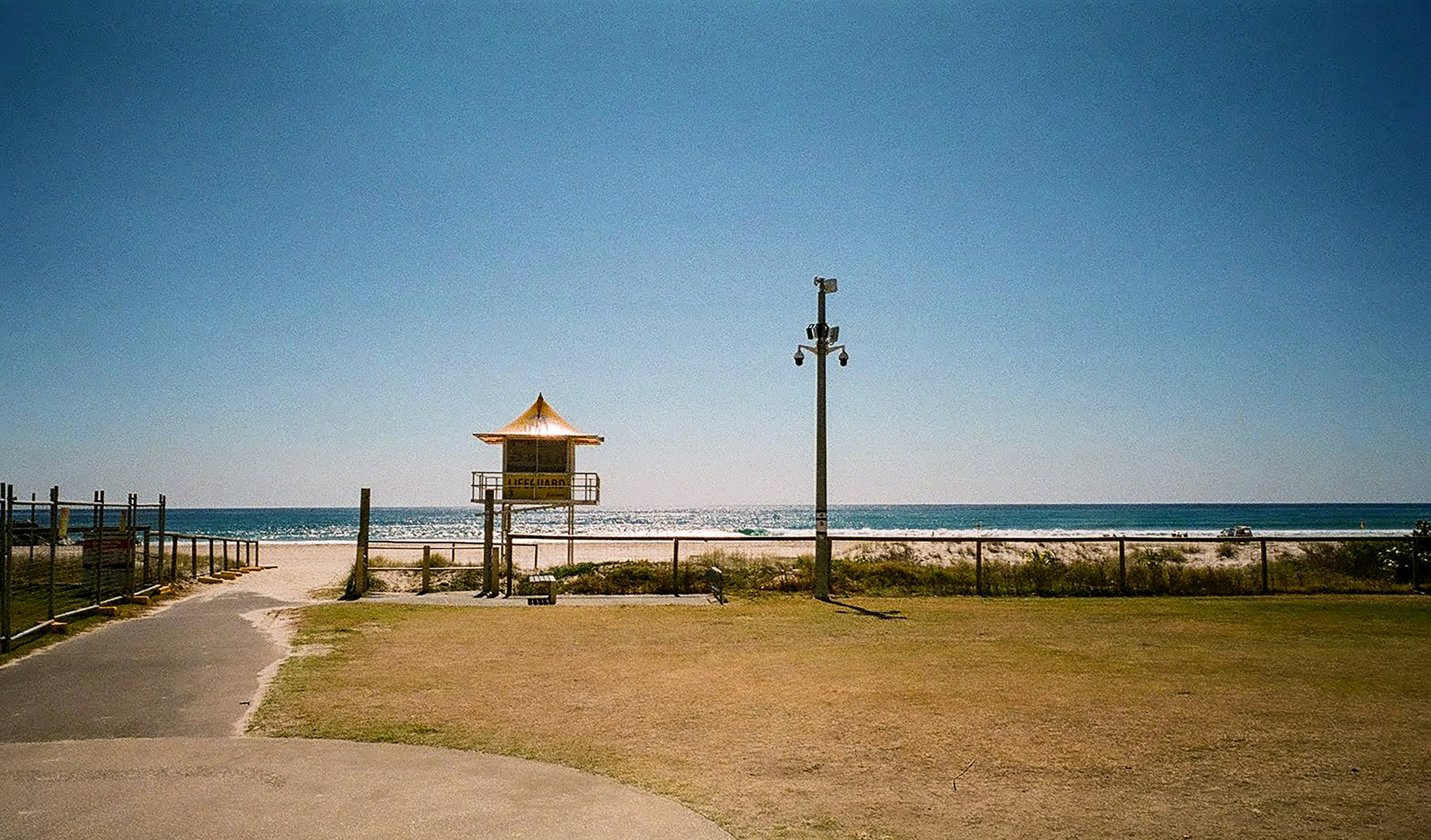 brown wooden post on brown sand near body of water during daytime