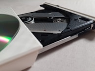 A close-up of a CD spinning inside a transparent player with LED lights.