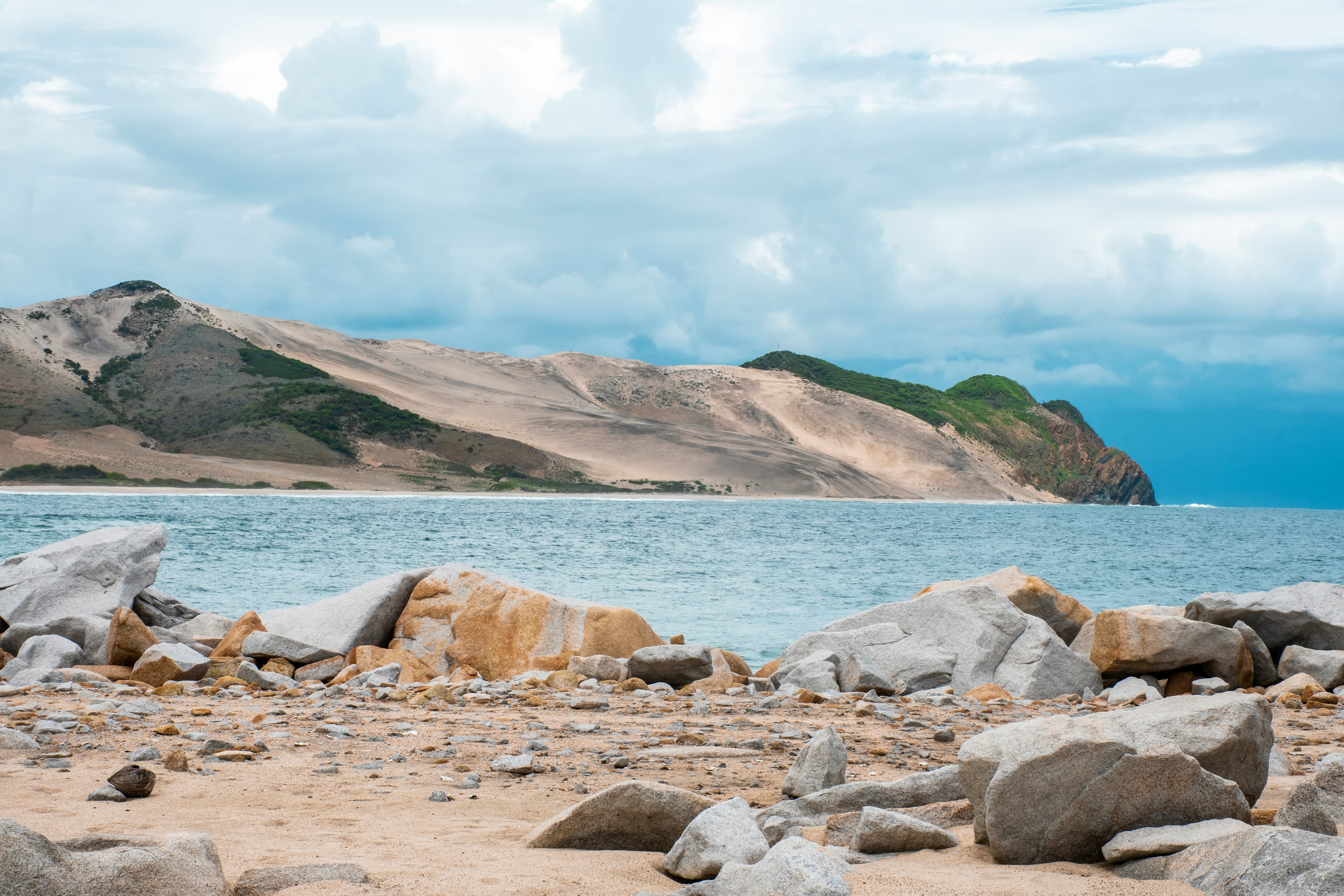 brown rocky shore near body of water during daytime