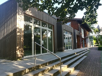 Exterior shot of a modern community center with large windows and green landscaping.