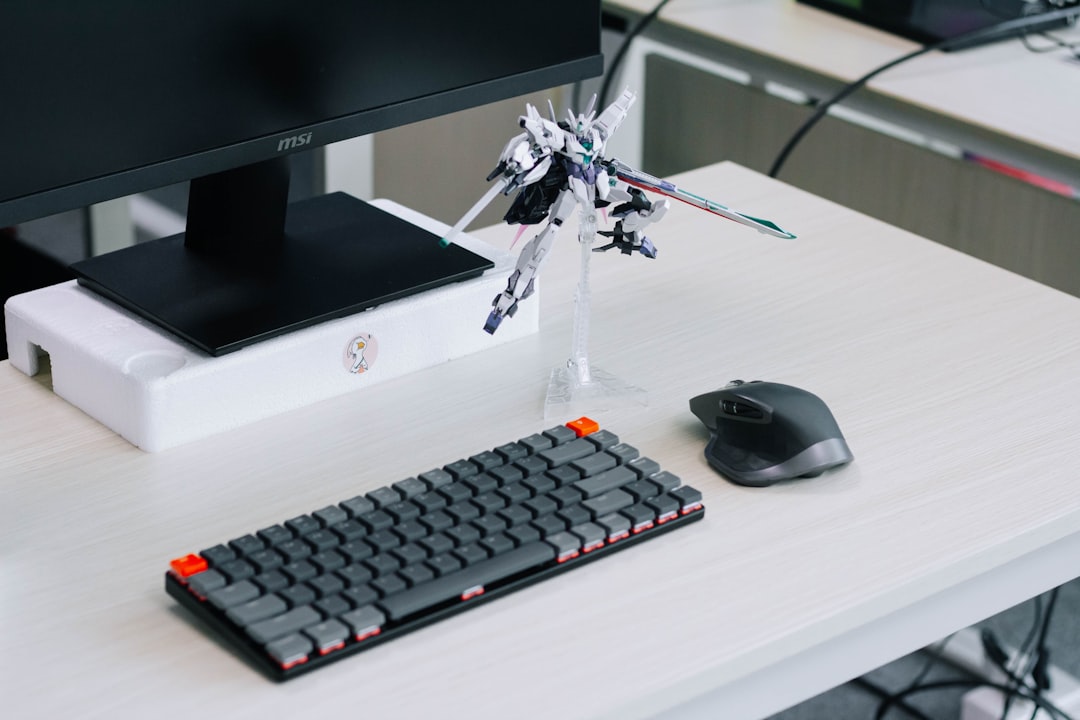 black cordless computer mouse beside silver imac