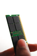 Close-up of hands installing new RAM into a desktop computer.