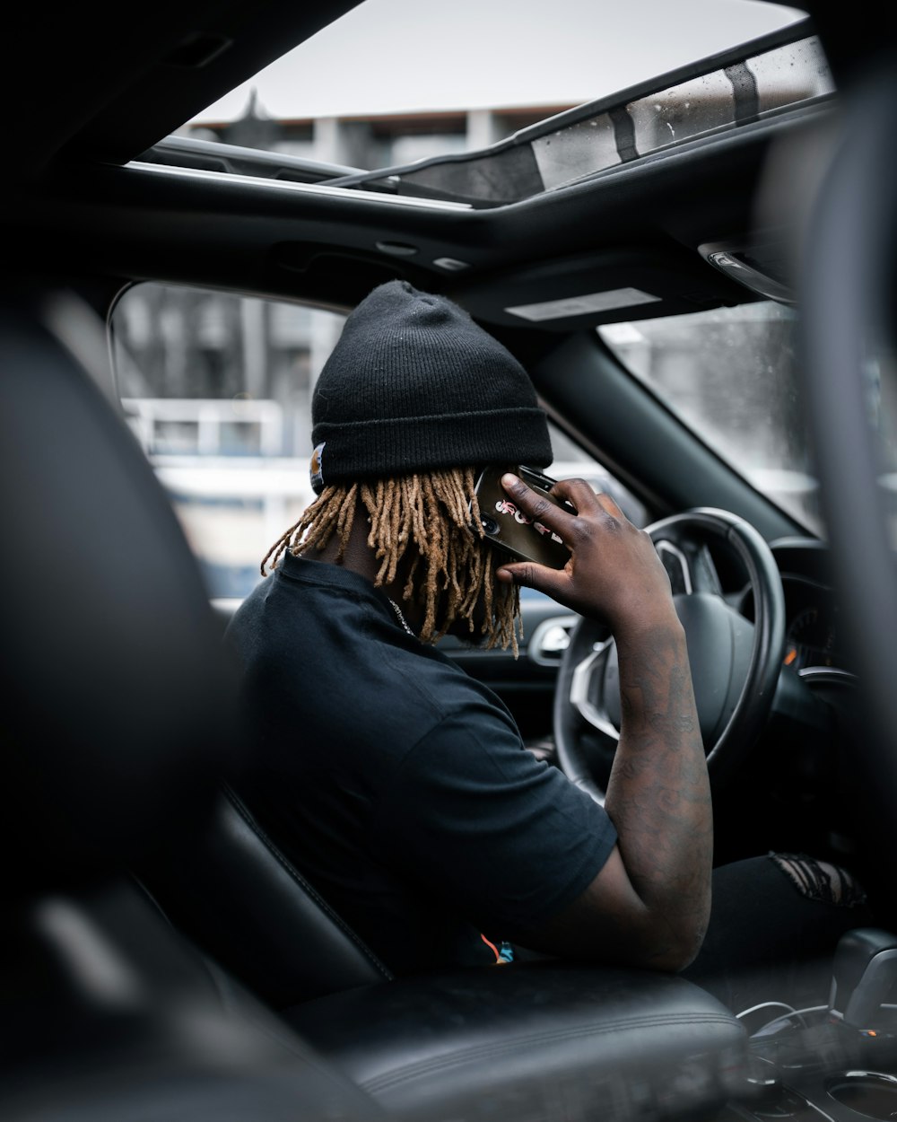 woman in black knit cap driving car