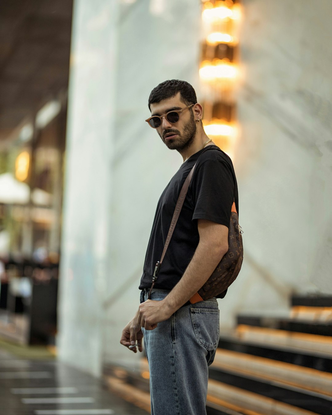 man in black crew neck t-shirt and blue denim jeans wearing black sunglasses