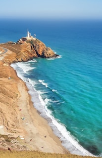 white and brown concrete building on brown sand beach during daytime